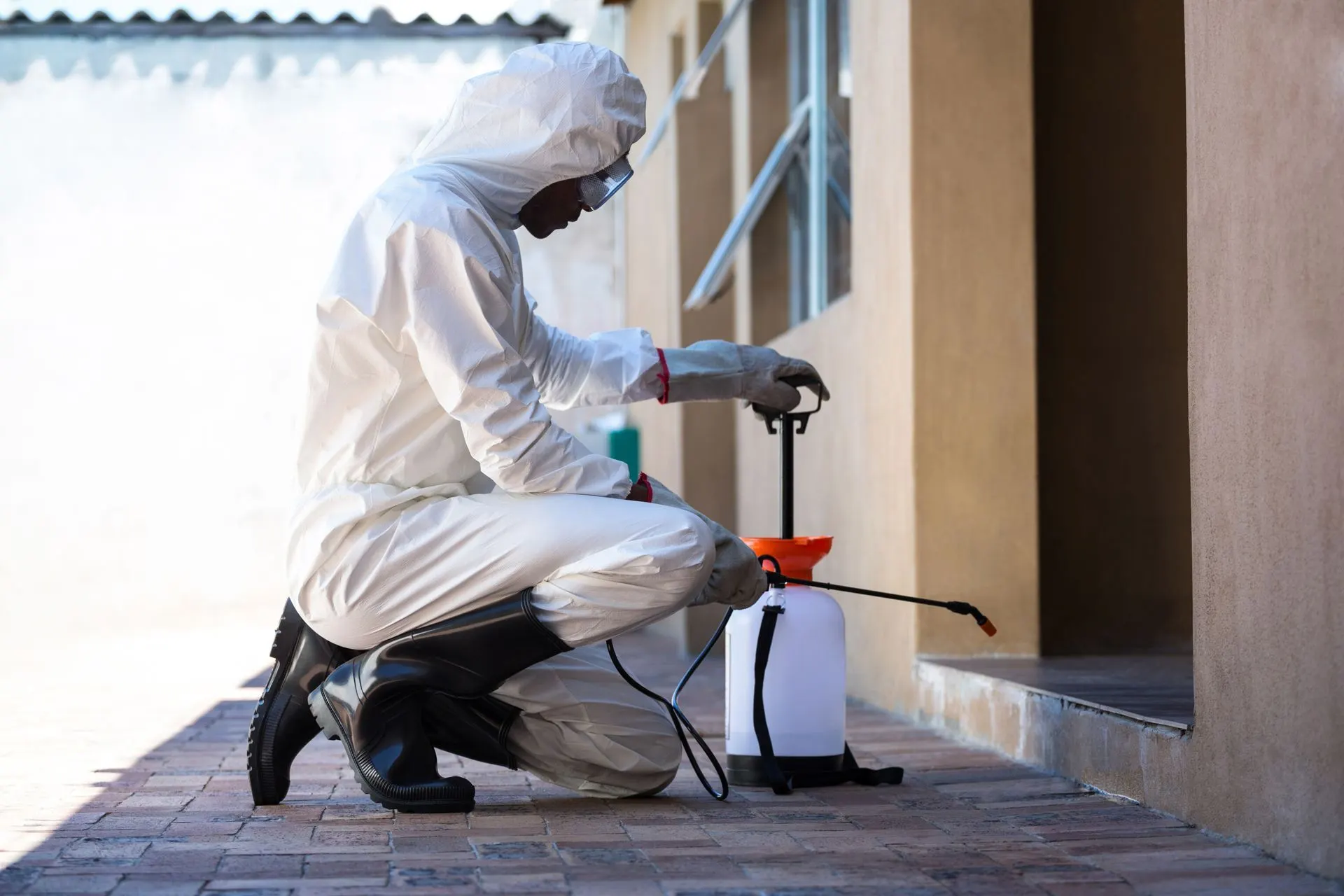 Empire technician in protective gear treating the entrance of a Wilson home
