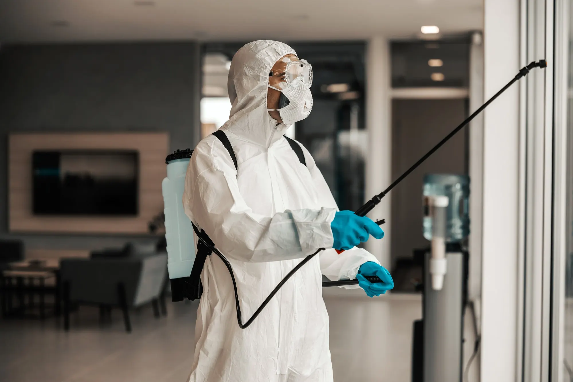 Technician in a protective suit treating a commercial lobby